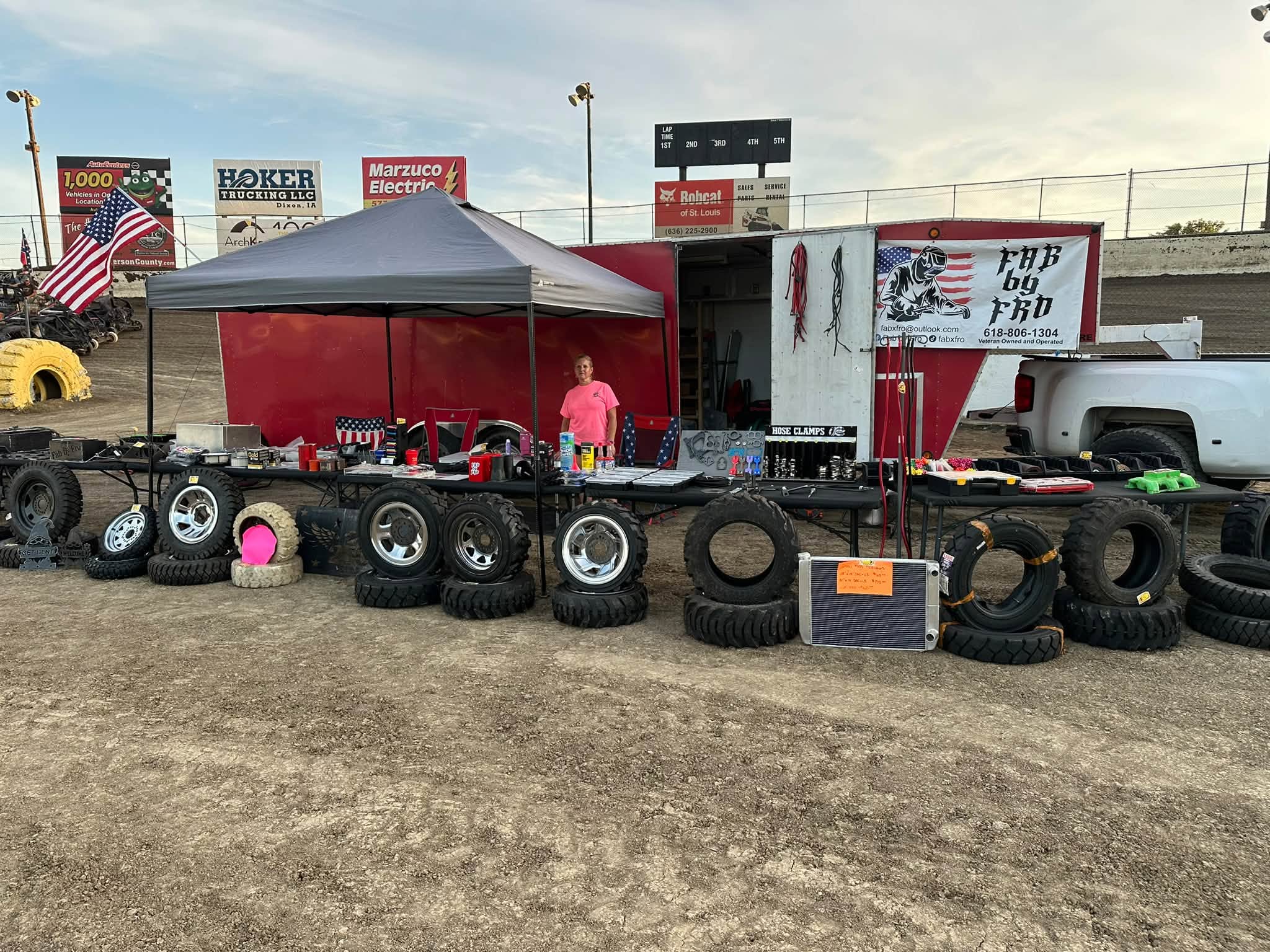 FAB by FRO trackside setup with parts trailer, tires, and banner